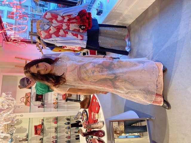 A customer at Zelda's in a sheer printed dress, with the shoe wall behind her
