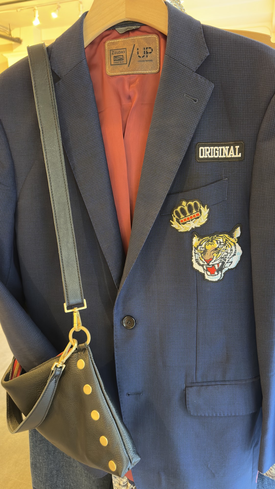 A patched navy blazer and studded bag at Zelda's